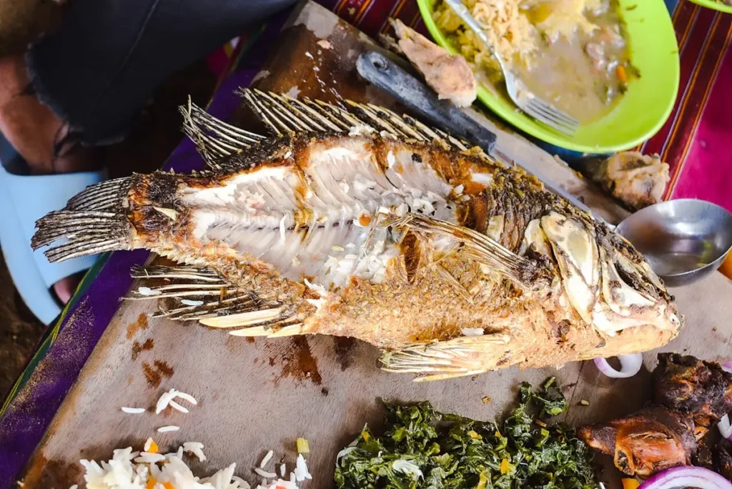 Whole deep-fried fish served with chips and sauce