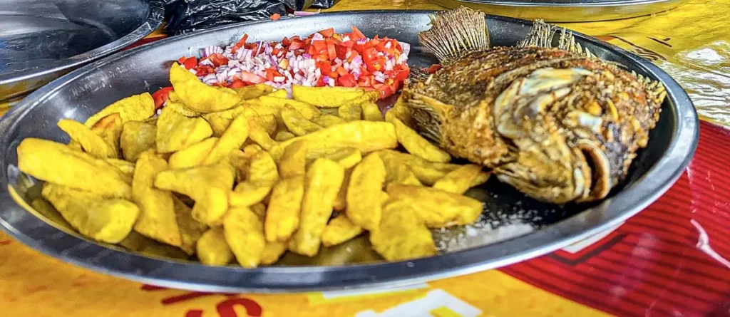 Platter of crispy fried tilapia with chips and kachumbari