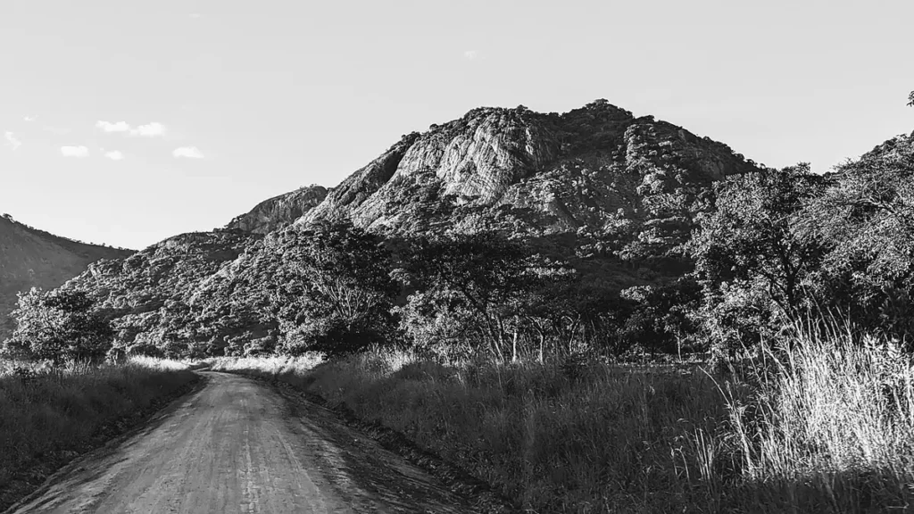 Dirt road leading towards rocky mountains in Kidepo Valley National Park
