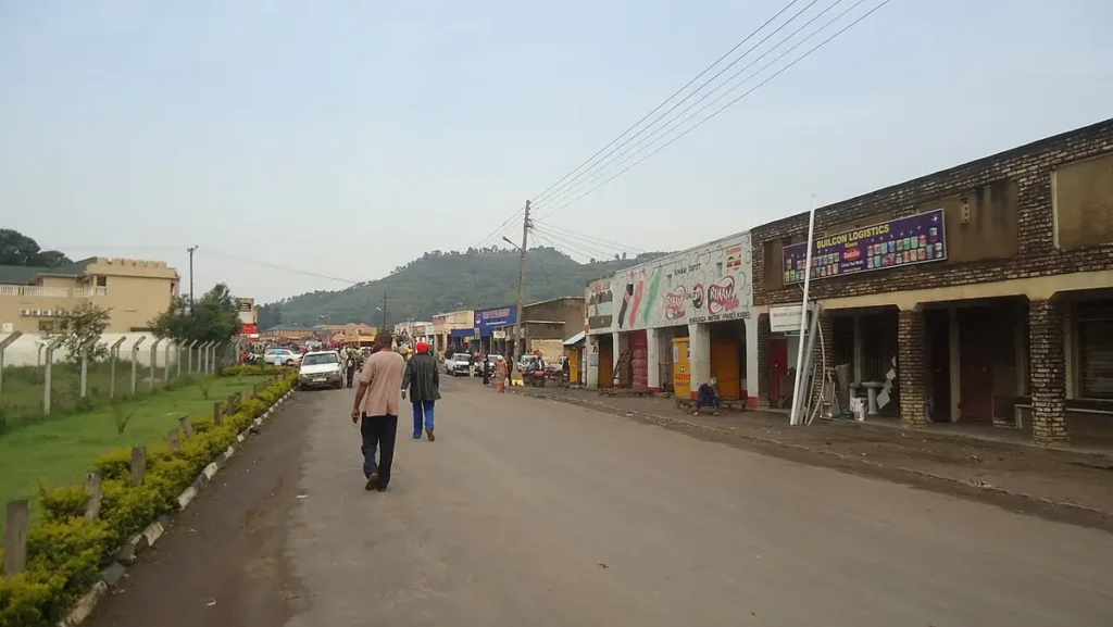 Main street in Kisoro town with shops and hills behind