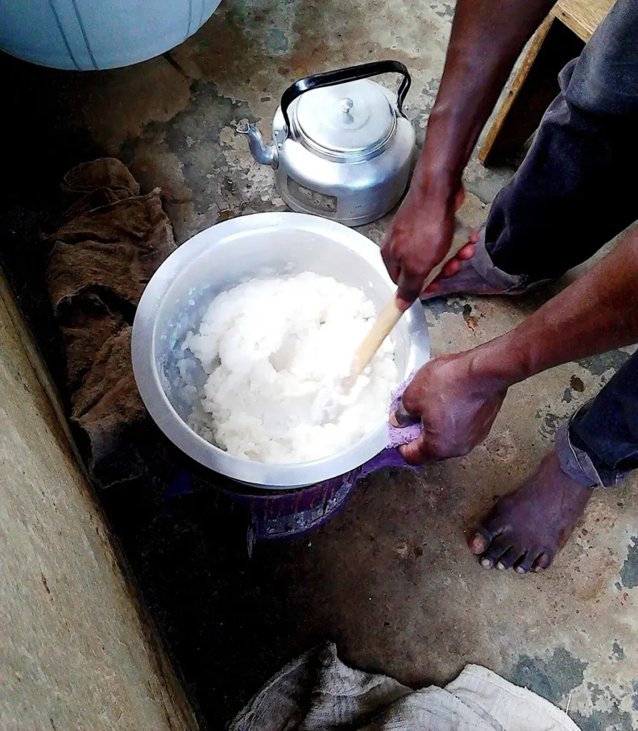 Stirring maize flour in a pot to make posho